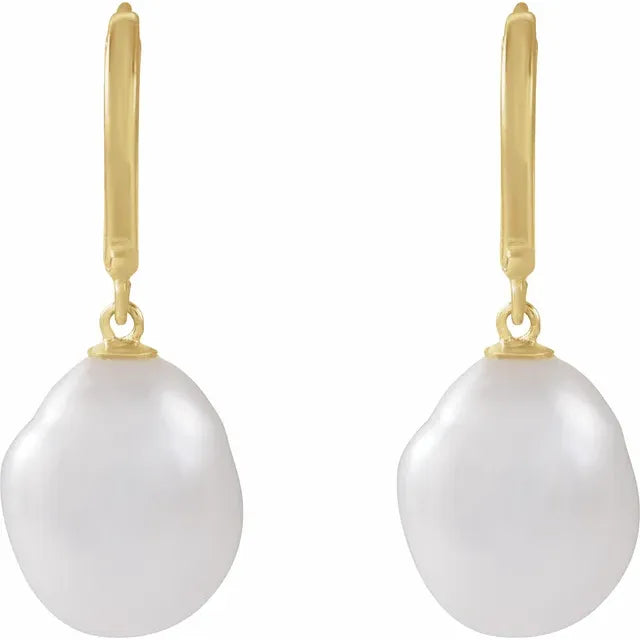 A pair of gold hoop earrings with white freshwater keshi pearls attached to them, displayed against a white background.