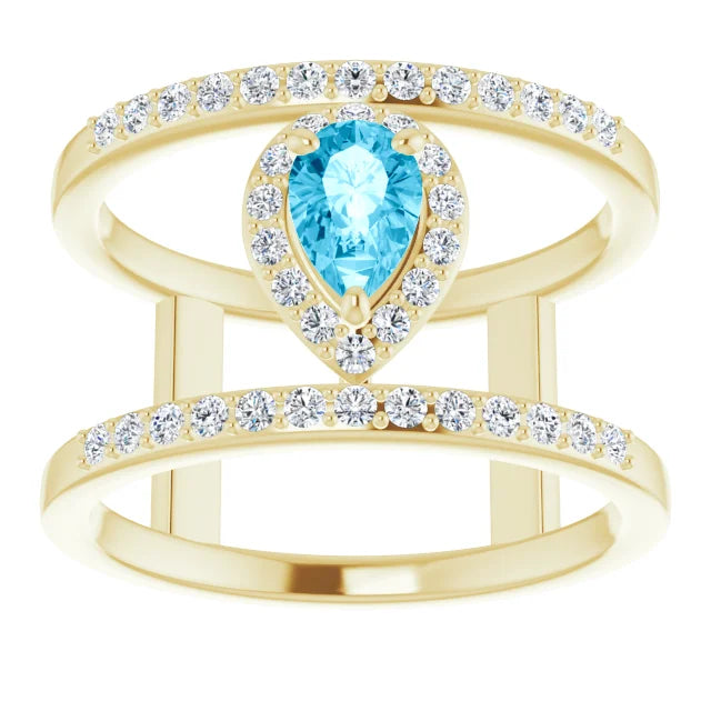 A pear-cut aquamarine ring with a halo of lab diamonds, set in solid 14K gold.