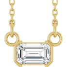 Gold necklace with a rectangular diamond pendant on a white background