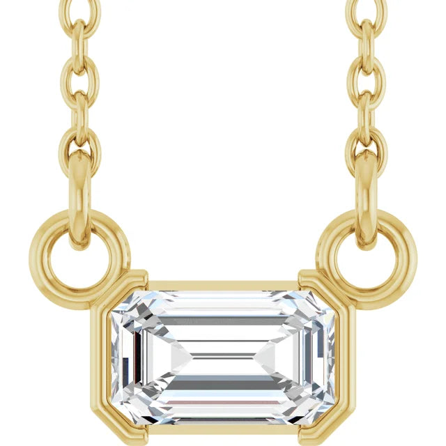 Gold necklace with a rectangular diamond pendant on a white background