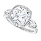 Diamond ring with a large central gemstone and smaller side stones on a white background